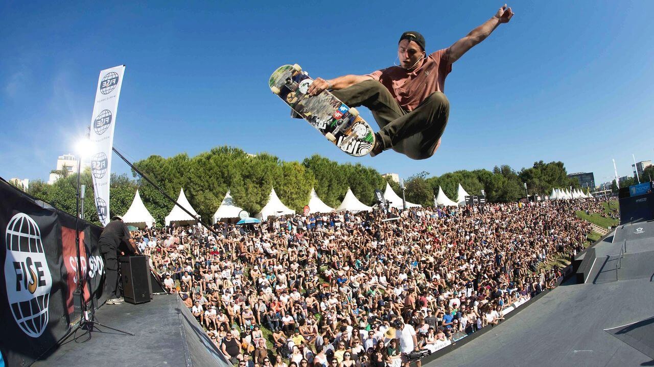 Photo prise lors du Fise World Montpellier. On y voit une foule de festivaliers derrière un homme qui fait une acrobatie en skateboard.